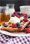 Belgian waffles with fresh berries and whipped cream, soft focus