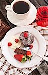 Chocolate muffin served on a plate with fresh berries and cream