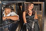 Tough male and female gangsters with shotgun in car