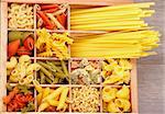 Various Raw Dry Pasta in Wooden Box closeup
