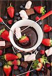 Chocolate fondue with fresh berries and marshmallows on wooden table
