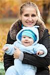 Young woman with baby in autumn park