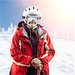 Senior woman in ski jacket and goggles outdoors. With path.