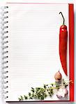 Open blank ringbound notebook surrounded by a fresh vegetables and spice for your shopping or grocery list