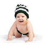 Happy baby boy in knitted hat crawling over white