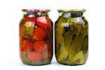 Two clear glass jars of colorful pickled vegetables: tomatoes and cucumbers