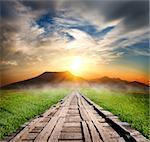 Wooden road in the mountains at sunset