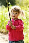 a beautiful little girl in nature playing with a stick