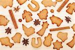 Various gingerbread cookies with spices on wooden table background