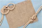 Ship rope with burlap on blue wooden texture background with copy space