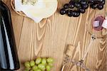 Red wine, cheese and grape on wooden table background with copy space