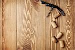 Corkscrew and wine corks on wooden table background with copy space