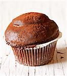 Sweet chocolate muffin on a white wooden board. Rustic style.