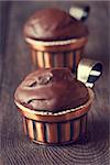 Delicious chocolate muffins in a metal cups on wooden background. Toned photo.