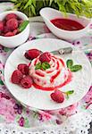Delicious dessert (panna cotta) with raspberry sauce decorated with fresh berries and mint