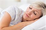 Pretty mature woman sleeping with eyes closed in the bed