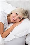 Closeup portrait of a pretty mature woman resting in bed