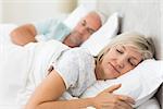Closeup of a mature couple sleeping with eyes closed in the bed at home