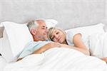 Closeup of a loving mature man and woman lying in bed at the home