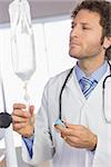 Professional doctor examining intravenous drip in hospital