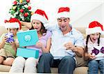 Excited family opening Christmas presents at home