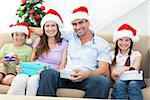 Portrait of happy family with Christmas presents at home