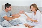 Frustrated couple arguing in bedroom