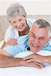 Portrait of loving senior couple relaxing in bed at home