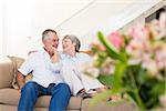 Loving senior couple relaxing on sofa at home