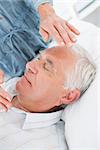 Closeup of senior man receiving Reiki treatment by therapist at health spa