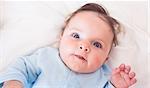 High angle portrait of lovely baby boy lying in bed