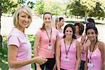 Portrait of confident female participants at breast cancer campaign in park