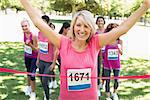 Portrait of happy female winner of breast cancer marathon race at park