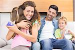 Little girl giving present to her happy mother at home in living room