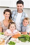 Smiling family preparing vegetables together at home in kitchen
