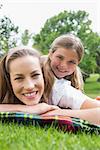 Close-up portrait of a happy mother with daughter lying at the park