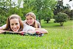 Portrait of a happy mother with daughter lying at the park