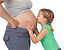 Little girl kissing her mothers baby bump on white background