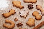 Gingerbread cookies with spices and flour over wooden table