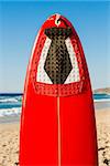 Red surfboard on the sand on a very beautiful sunny day