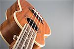Close-up shot of ukulele guitar, studio shot on grey background, selective focus