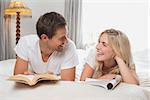 Relaxed casual young couple reading books in bed at home
