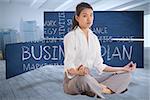 Businesswoman sitting in lotus pose against city scene in a room