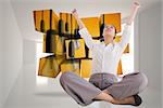 Cheering businesswoman sitting cross legged against bright hall with windows