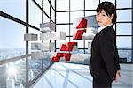 Serious businesswoman against room with large windows showing city