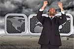 Happy businessman with raised arms  against misty landscape with bales of straw