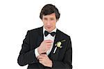 Portrait of handsome groom in tuxedo getting ready over white background