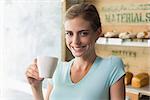 Portrait of a smiling young woman drinking coffee in the coffee shop