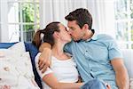 Loving young couple kissing in the living room at home