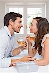 Side view of a loving young couple with wine glasses looking at each other